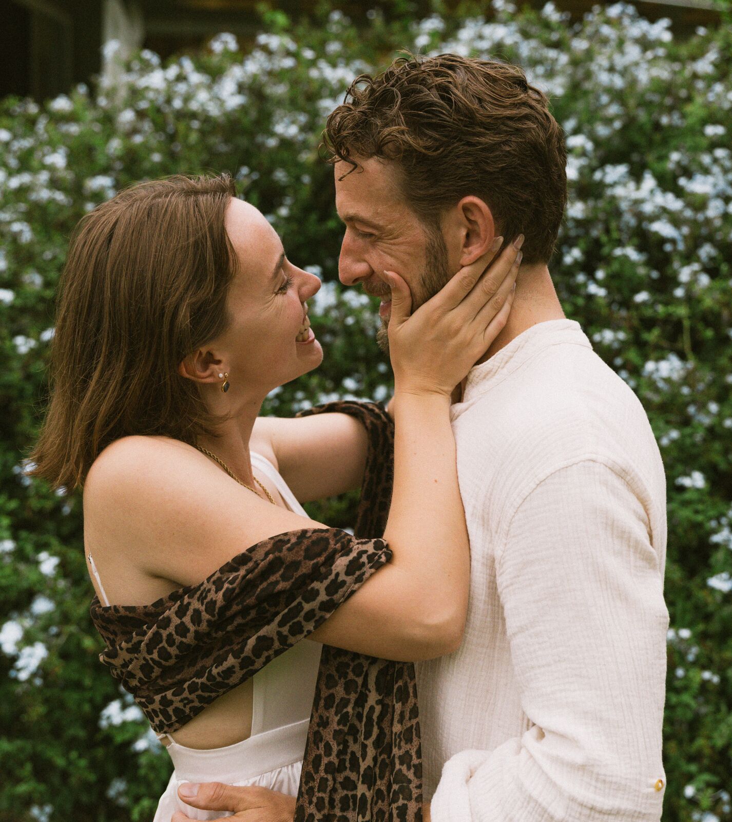 Carley & Tommy — an embrace beside the blossom wall