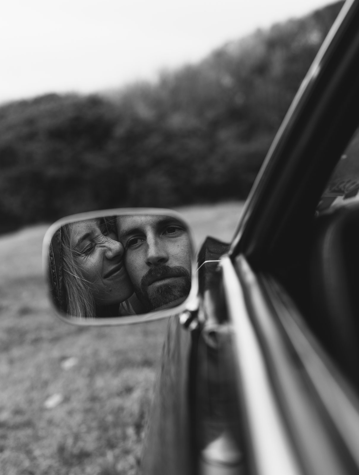 Couple reflected in a car side mirror, black and white film